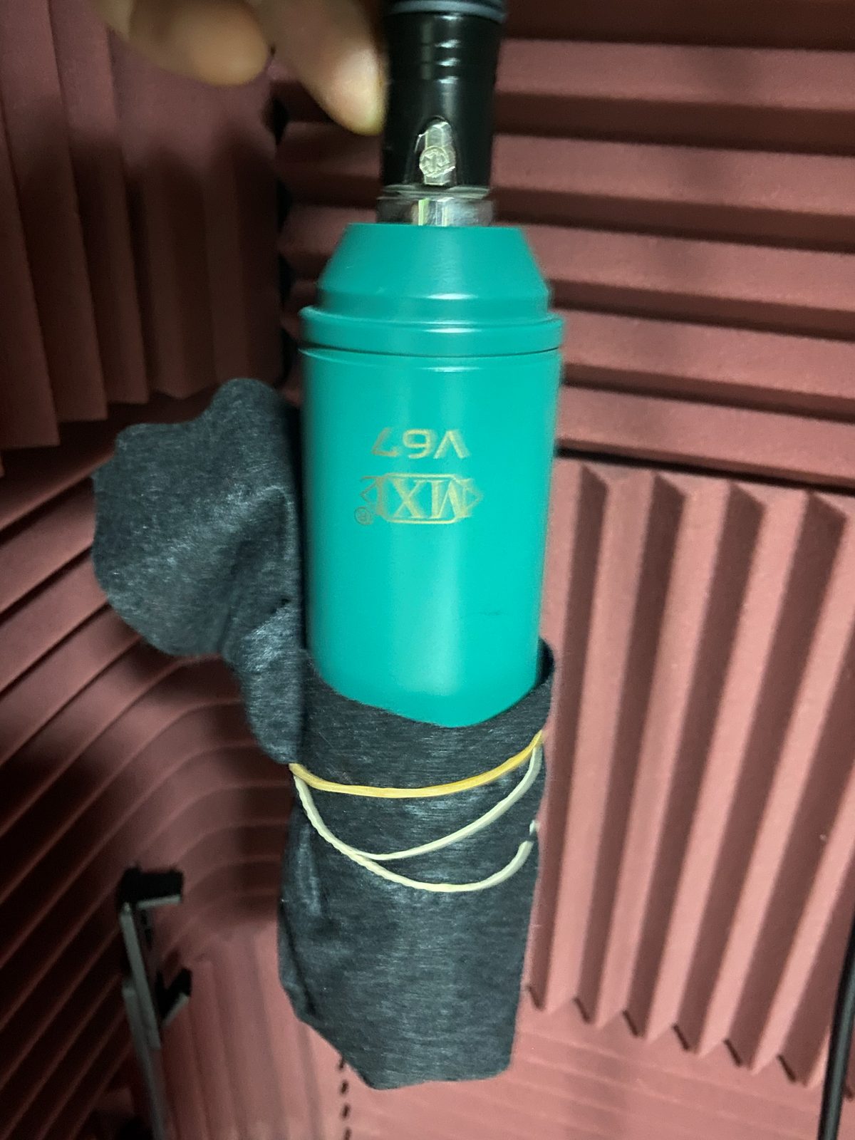 Condenser microphone used for indoor recording, with a green body wrapped in black cloth