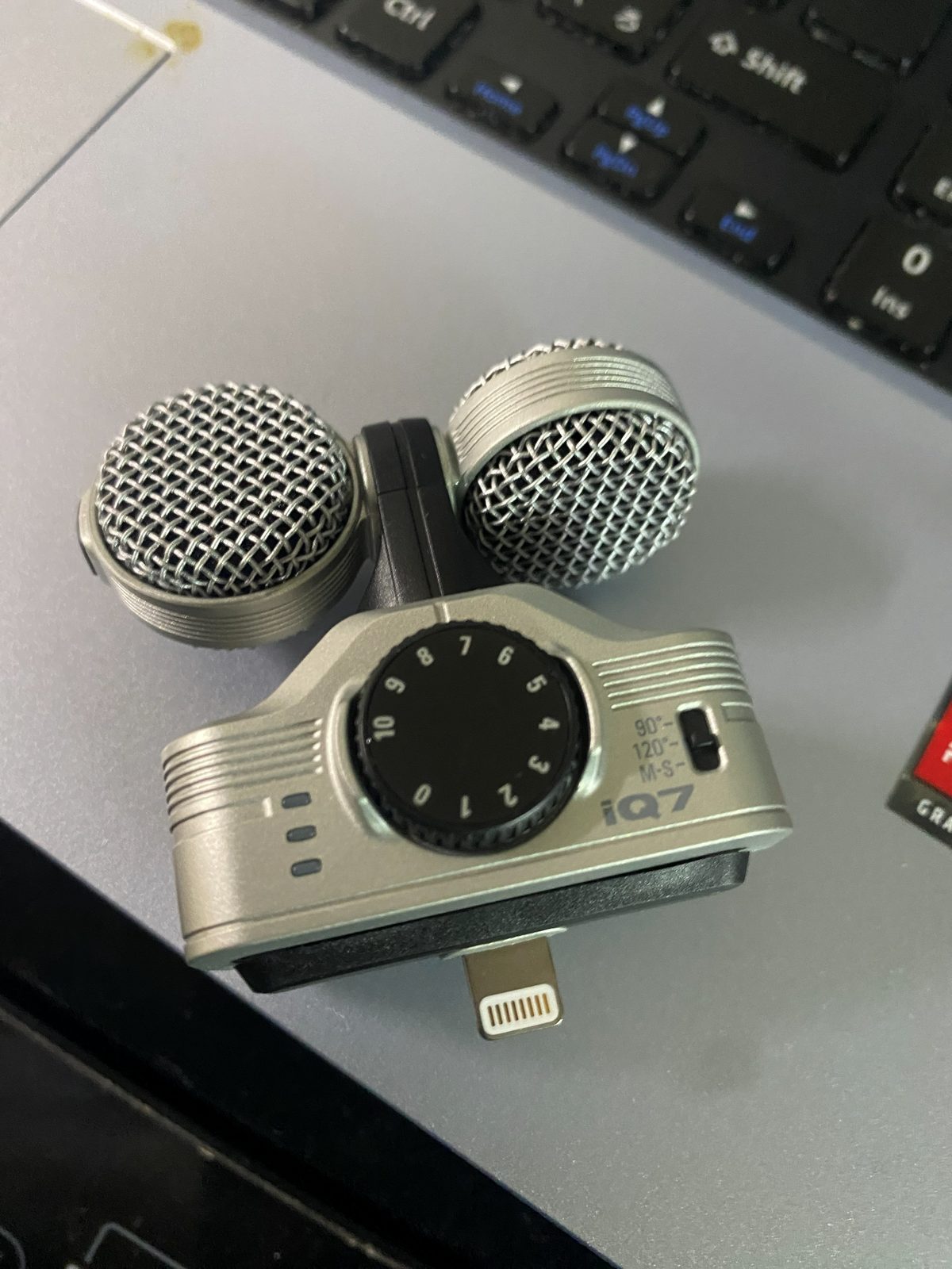 ZOOM iQ7 stereo microphone with two microphone capsules, an input gain knob on the front, a switch for 90°, 120° and M-S, and a Lightning connector at the bottom